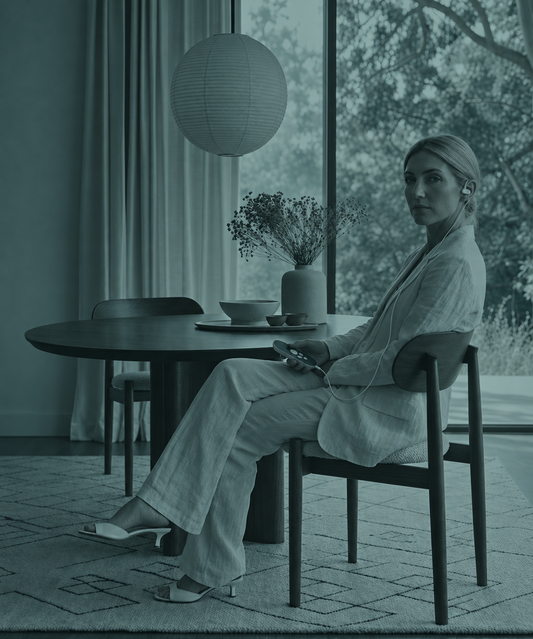 A Nurosym user sitting down at a table and looking relaxed while using the device