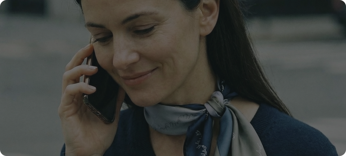 Woman on a phone call holding a coffee cup on a city street