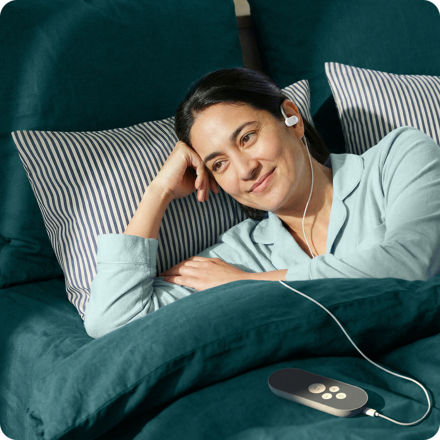 Pessoa a utilizar o dispositivo Nurosym® no ouvido durante um momento de descanso